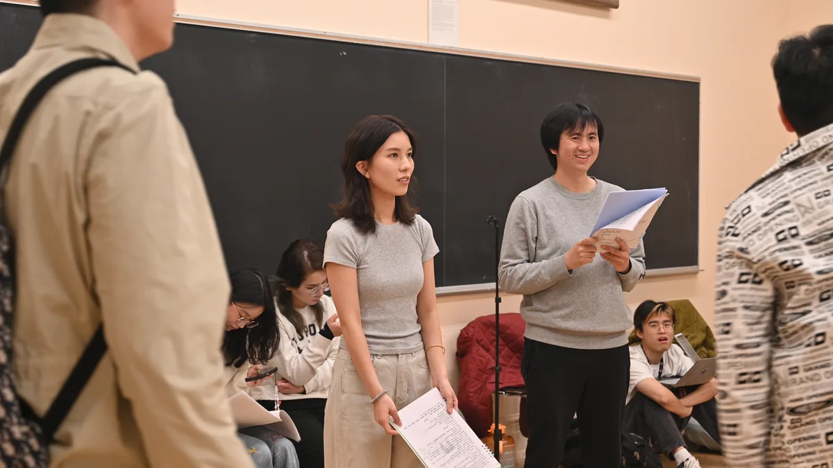 《夏洛特烦恼》成员手持剧本，在教室进行围读 / May Drama members reading scripts together for Goodbye Mr. Loser